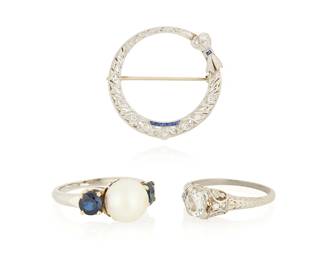 1026
A Group of Platinum and Diamond Jewelry
Including a round openwork brooch accented by diamonds and sapphires, an engraved platinum and diamond ring together with a ring featuring two round sapphires centering one cultured pearl
3 pieces

Ring: 5 1/2, Brooch: 1 1/4 in.
13.7 grams gross
Estimate: $600 - $800