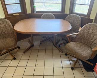 CHROMCRAFT GENTLY USED DINETTE TABLE WITH 1 LEAF AND 4 TILTING SWIVEL CASTER CHAIRS. WOOD STRUTURE WITH METAL PEDESTAL BASE