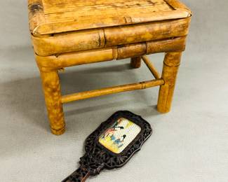 A vintage scorched bamboo riser or plant stand, and a vintage Chinese mirror featuring a heavily carved wooden frame and handle with inset panel depicting two women 
