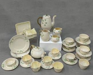 Vintage Belleek porcelain including a 16-oz Shamrock jug or pitcher, 3 Shamrock salad plates, a Belleek Pottery Shamrock coffee pot, teapot, sugar, and creamer; a vintage Belleek "Shamrock" open butter tub, 4 Belleek Pottery Harp Shamrock cups with 3 matching saucers, 1 Belleek Ireland Tridacna cup, 2 Belleek Shamrock teacups, 5 Belleek Shamrock flat cups, 11 Belleek Ireland porcelain saucers, and a vintage Belleek Pottery figural cheese dish with lid