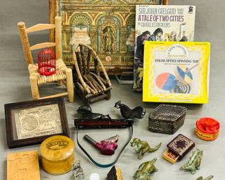 A group of vintage toys including handmade wooden chairs, tin whistles, rubber stamps, brass dinosaur figurines, an antique "pecking chicken" or "two chickens eating" metal toy, and a "Color Optics Spinning Top" kit