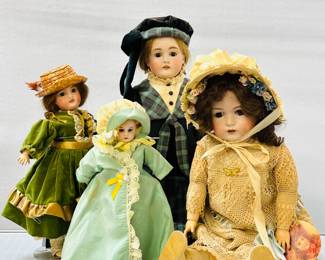 A variety of antique and vintage dolls available at this sale including a 20-inch bisque head doll wearing a plaid and black hat, blouse and skirt