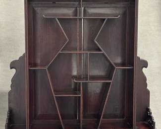 A Chinese carved wood display shelf or curio cabinet designed for showcasing collectibles
