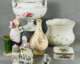 A vintage Limoges France porcelain trinket box hand-painted with a fruit basket and bird motif, the hinged lid with gold-toned metal fittings and a decorative wreath-shaped clasp; a Derby porcelain twin handled pedestal bowl with enameled floral decoration, a Royal Crown Derby porcelain bud vase with hand painted floral decoration and gilding, a Belleek Ireland porcelain Shamrock Daisy pattern planter or cache pot, porcelain figurines including a Meissen porcelain "Touch" figurine, by Johann Carl Schonheit, from the Five Senses series; woman interacting with a bird in a cage, the base with underglaze crossed sword mark in blue, stamped 72.