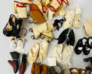 A selection of antique and vintage doll shoes, doll roller skates, booties, boots and slippers, many styles and sizes