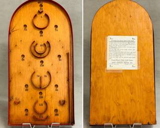 A vintage 1930s era "Green Duck Table Golf" bagatelle game – a tabletop pinball-like game made of wood with brass pins. The game was manufactured by The Green Duck Co. in Chicago, Illinois, as indicated on the directions label on the back. 