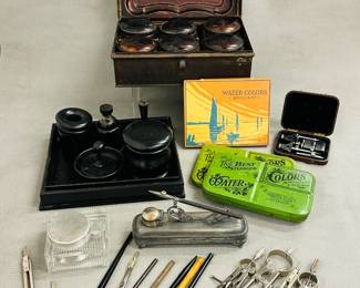 An antique metal spice box with 6 tin canisters with lids, a collection of vintage drafting tools including various types of compasses and ruling pens, two vintage Devoe "The Best Standard" watercolor paint tins, a vintage glass inkwell with metal lid, and an antique Homan Mfg silver plated Art Nouveau curling tongs spirit heater