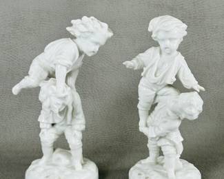 Closer view of the pair of white porcelain figurines (likely European) depicting two boys playing together