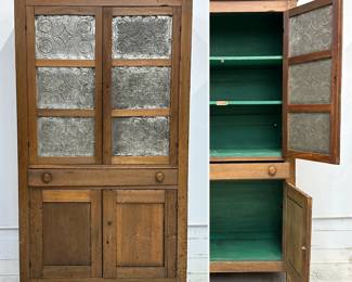 Antique American 19th Century wooden pie safe or jelly cupboard in two-part design with punched tin panels on the upper cabinet doors, a central drawer, lower cabinets, and original wood turned knobs.