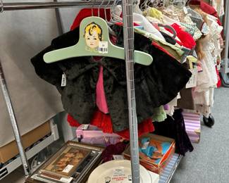 Racks of vintage doll clothes, and some Dionne Quintuplets collectibles