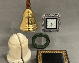 A brass hand bell with wooden handle, a set of vintage carved alabaster or marble bookends, a Brighton Tango square clock, a vintage bronze paperweight / magnifying glass