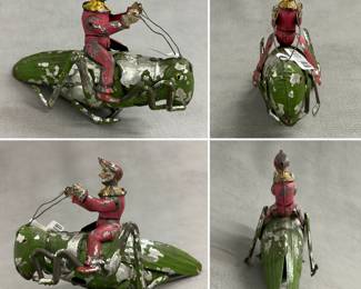 A rare, antique tin wind-up toy featuring a clown riding a grasshopper, manufactured by the Eberl Toy Company in Germany around 1910-1915.