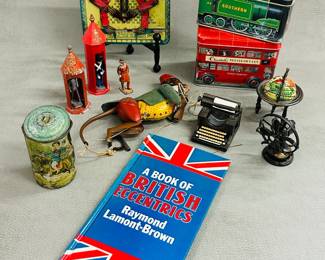 A hardcover copy of A Book of British Eccentrics, and a collection of vintage tin litho containers and toys including antique Consul the Educated Monkey calculator, a vintage German Lehmann EPL No. 385 'Tom the Climbing Monkey' tin toy, miniature typewriter, and more 