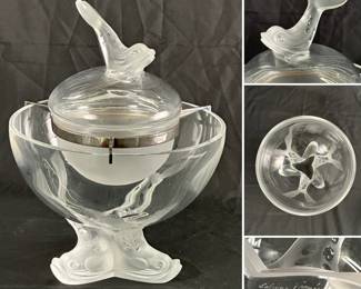 A stunning Lalique "Igor" pattern crystal caviar serving bowl. The set includes a large clear glass bowl with a dolphin tripod base designed to hold crushed ice, a frosted glass insert dish for the caviar, and a lid topped with a dolphin finial. The insert dish is held in place by a silver-plate metal frame.  The piece was designed by Marie-Claude Lalique in 1969 and is signed "Lalique France"
