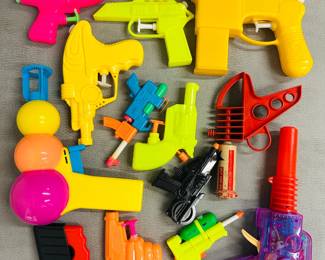 A collection of brightly colored toy water guns and a vintage Tigrett Enterprises Zoomeray toy ray gun and a vintage Eagleton Space Invader Star Gun 