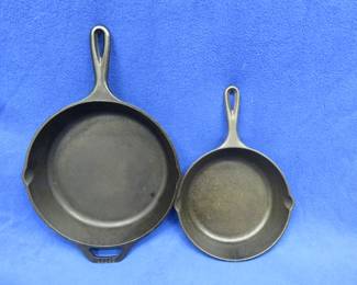 Lot 20. Two Lodge cast iron skillets in very good condition. One is a 10" with a helper handle marked with 2 and 8SK, the other is an 8" marked 5SK