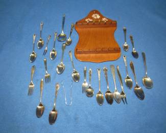 Lot 98. Spoon holder with spoons of unknown composition. Nine have hallmarks.