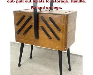 Lot 268 Mid Century Sewing Box. Two swing out pull out levels for storage. Handle. Raised on legs. 