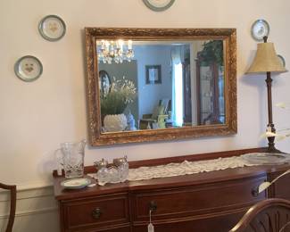 Mahogany buffet with mirror and plates .