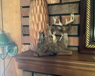 Wood carved vase with deer statue on mantel.