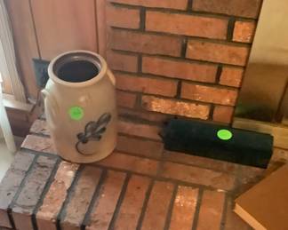 Crock sitting on mantel .