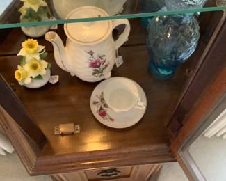 Items in glass lighted curio cabinet in living room.