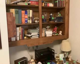 Book cases on wall in twin bedroom with desk with 2 drawers.