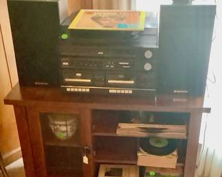 A wood cabinet with shelves and glass door holding the record player and cd player with speakers. Has a beautiful sound.
