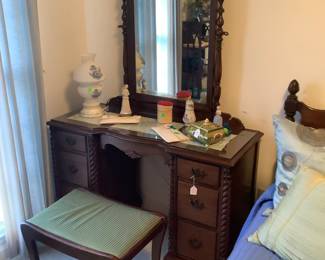The antique mahogany dresser with matching stool with green fabric.
