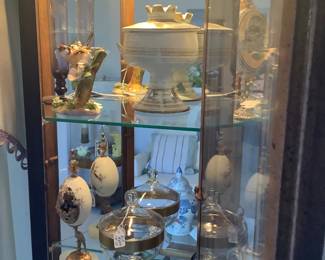 Carved eggs in curio cabinet.