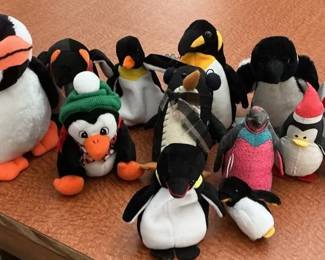 Assortment of Small Penguin Stuffed Animals and Beanies
