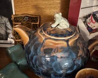 Japanese ceramic tea set features a teapot and multiple cups adorned with a distinctive blue and amber crystalline glaze, likely in the style of Kutani ware. 