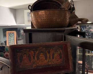 red lacquer Buddhist panel, hand-hammered copper wash basin with dual handles • Vintage copper stock pot and traditional cookware • Decorative carved mask wall art • Framed stained glass panel • Global-inspired decorative wood accents