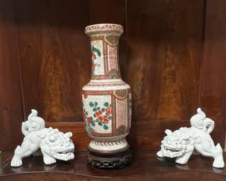 Pair of White Porcelain Foo Dogs with a Famille Rose Vase