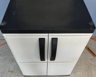 L27 - $20. Plastic 2 Door Garage Storage Cabinet. Approximately 2' tall.