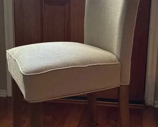 Upholstered side dining chairs with a high back and natural wood legs