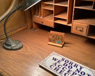 vintage desk lamp, ceramic NO CHECKS tile, 1880s oak roll-top cashier's desk  