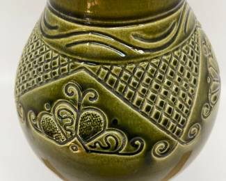 K7 - $35. Vintage olive green vase. Signed. Signed Anna Grandina. Chips on the base. Measures 7”w x 7”d x 10”t.