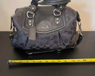 K4 - $45. Coach Ashley Signature black canvas handbag with leather trim, in black. Excellent condition. Measures 11.5”w x 4.5”d x 7”t.