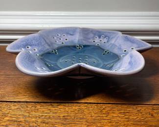 K31 - 25. Studio pottery flower shaped shallow bowl with holes. Decorative colander or fruit bowl. Signed Redman. Nancy Redman, local NC potter. Measures 11”w x 11”d.