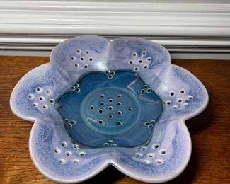 K31 - 25. Studio pottery flower shaped shallow bowl with holes. Decorative colander or fruit bowl. Signed Redman. Nancy Redman, local NC potter. Measures 11”w x 11”d.