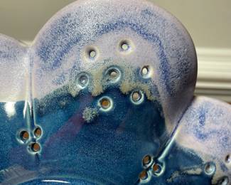 K31 - 25. Studio pottery flower shaped shallow bowl with holes. Decorative colander or fruit bowl. Signed Redman. Nancy Redman, local NC potter. Measures 11”w x 11”d.