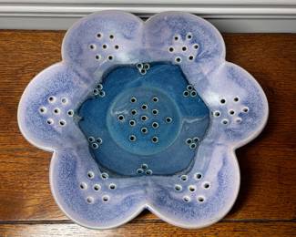 K31 - 25. Studio pottery flower shaped shallow bowl with holes. Decorative colander or fruit bowl. Signed Redman. Nancy Redman, local NC potter. Measures 11”w x 11”d.