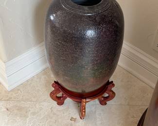 Pottery urn on wood base