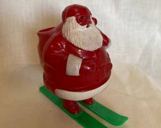 A vintage 1950s Rosbro hard Plastic Santa Claus candy container on green skis, approximately 4.25 to 4.5 inches tall