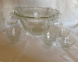 A vintage Indiana Glass Princess punch bowl set featuring a clear pressed glass construction with a harvest grape design & 12 rim-hanging matching cups, 