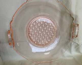 A vintage Lancaster Glass Co. Peaks Pink depression glass handled serving plate, featuring a caned pattern on the center base and scalloped edges