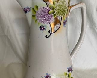 An antique, hand-painted porcelain Nippon chocolate pot, featuring a floral moriage design