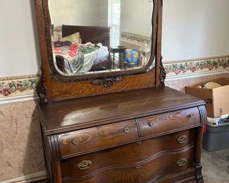 Antique Victorian Tiger Oak dresser with serpentine front and attached carved mirror . Location House 