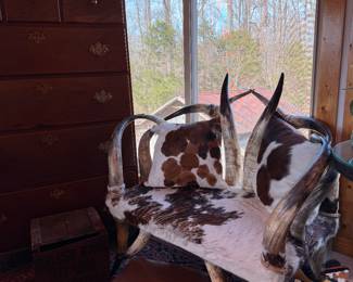 Texas steer horn settee couch chair with authentic longhorn construction, rawhide upholstery, and matching stool. Western ranch style statement seating, handcrafted rustic furniture, cowboy lodge décor, Southwestern interior accent, Texas ranch heritage piece, collectible Western horn furniture.